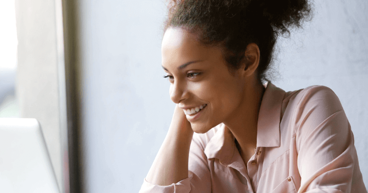 Woman smiling at her laptop.