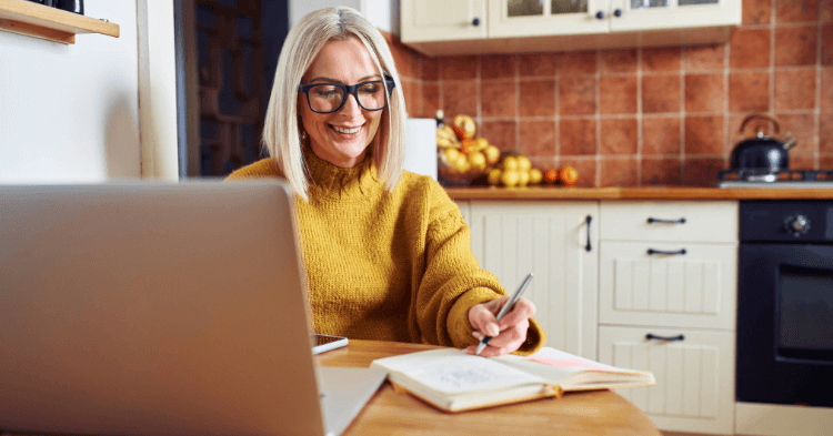 Woman checking on her finance on a laptop in her kitchen