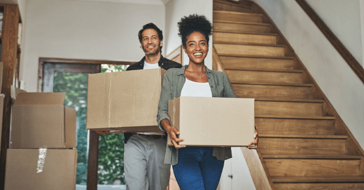 Two people holding moving boxes