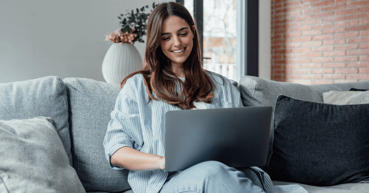 Woman sitting on her couch with her laptop in her lap
