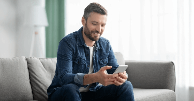 Man sitting on his couch on his phone
