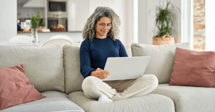 Woman on her couch looking at her laptop for an online loan