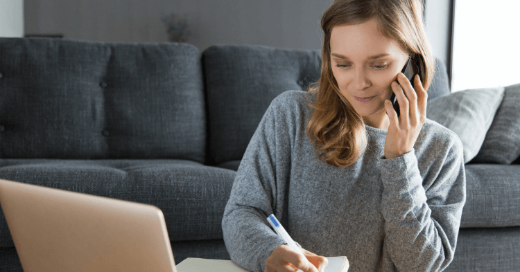 Woman on her laptop while making a phone call trying to get an overdraft fee refunded