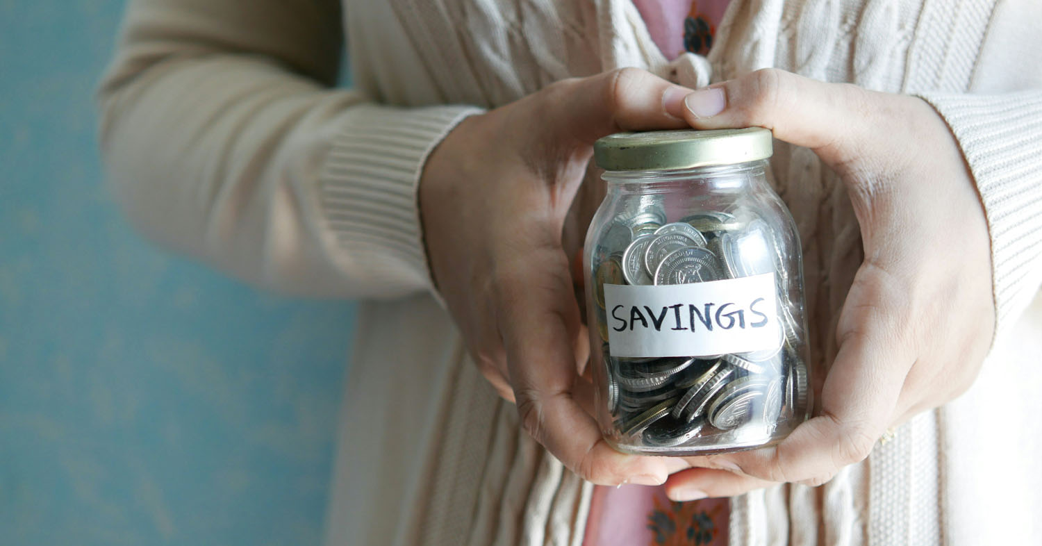 Woman holding a jar that says savings