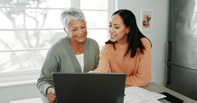 Mother and daughter talking about finances sitting at a laptop