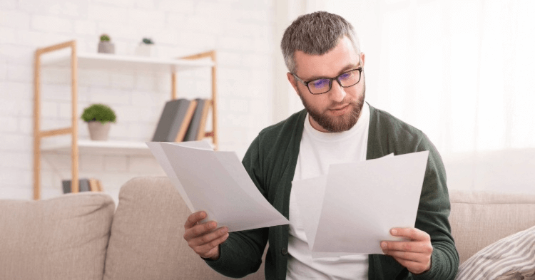 Man on his couch reviewing his credit report
