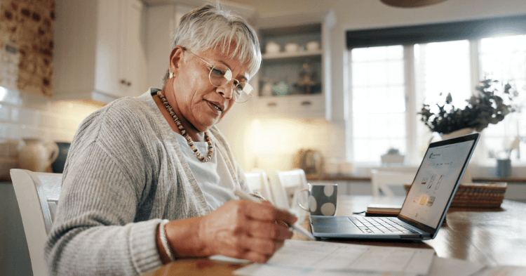 Woman at her kitchen table reviewing her credit report