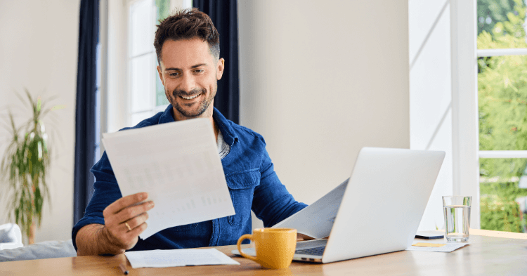 Man at kitchen table going through his finances and using the pay yourself first method